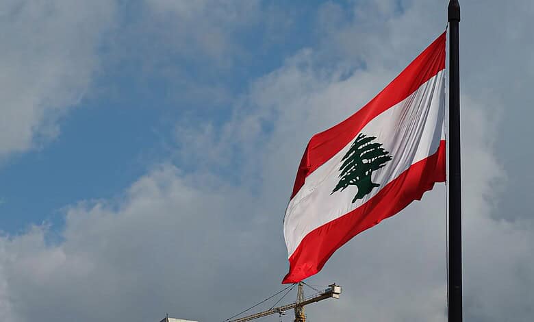 Lebanese flag waving in the wind against a cloudy sky.