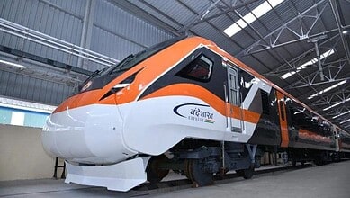 Indian Vande Bharat train inside a modern train maintenance facility.