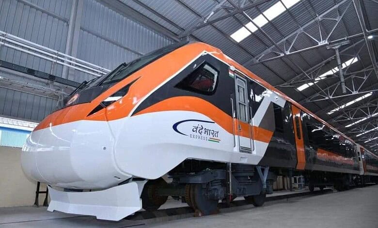 Indian Vande Bharat train inside a modern train maintenance facility.