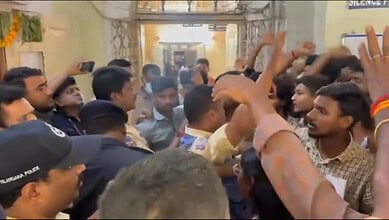 Police officials prevent students from entering the principal's chamber at Nizam College