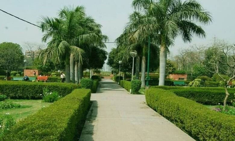 Well-maintained park with palm trees, benches, and a paved walkway in Medchal.