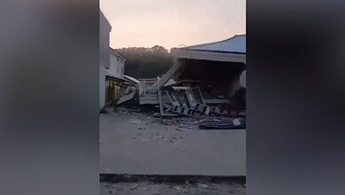 Damaged building and debris after earthquake in Indonesia, tsunami warning issued.