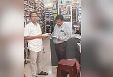 Two men in a pharmacy discussing weight loss drugs, shelves filled with medicines in the background.