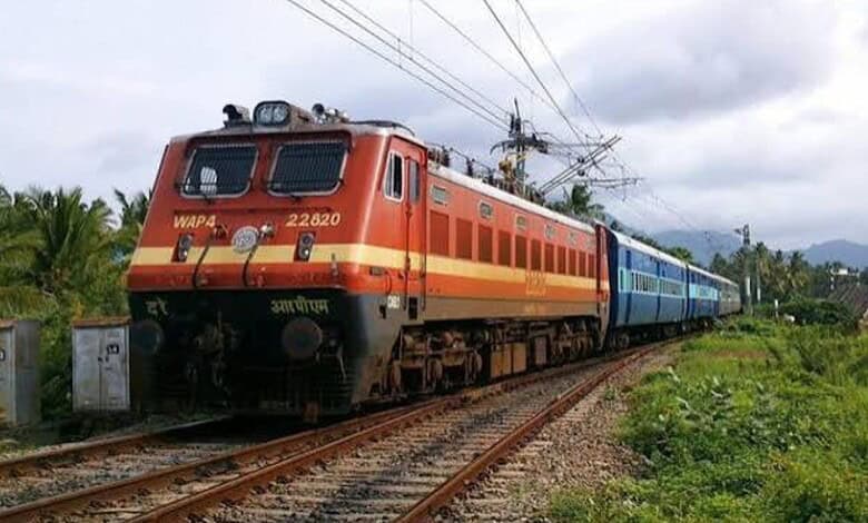 Electric train moving through lush green landscape near Hi-Tec City station during Dasara.