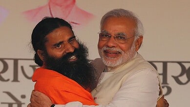 Prime Minister Narendra Modi embracing yoga guru Ramdev at a public event.