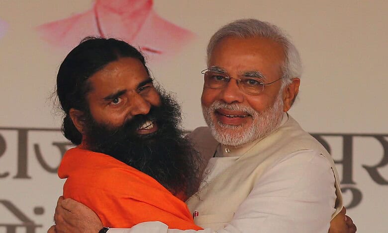 Prime Minister Narendra Modi embracing yoga guru Ramdev at a public event.