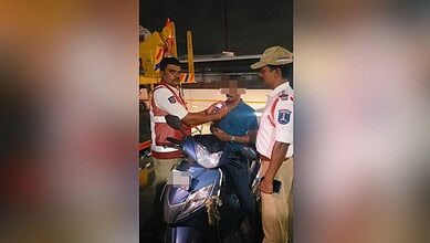 Police officer checks driver's documents during a roadside sobriety test in Cyberabad.