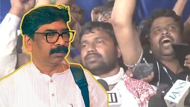 Man with glasses and mustache at a protest or rally, surrounded by crowd members.