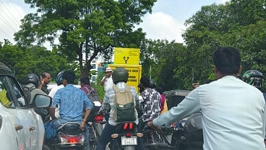 A Hyderabad Traffic police constable stands near a signage on the KBR Park road near Jubilee Hills on the first day of the first day of the road turning one way.