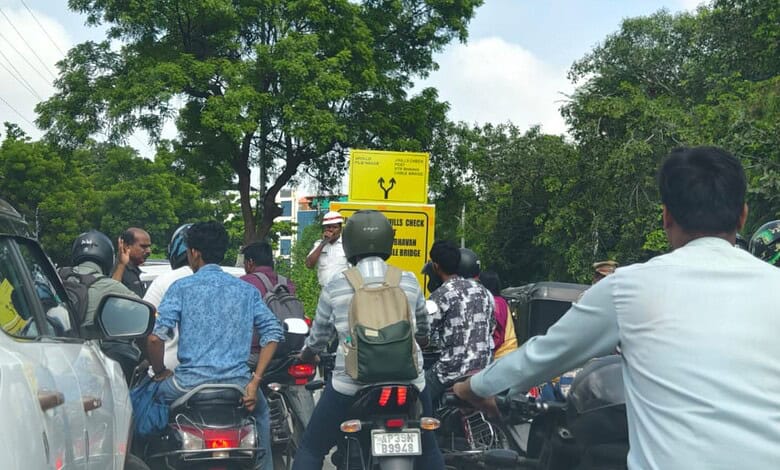 A Hyderabad Traffic police constable stands near a signage on the KBR Park road near Jubilee Hills on the first day of the first day of the road turning one way.