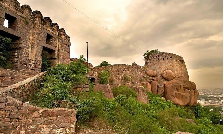 Ancient stone fortification at Golconda Fort with a cloudy sky in the background.