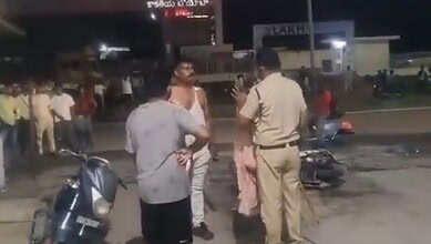 Police officer and civilians involved in a confrontation on a street at night.