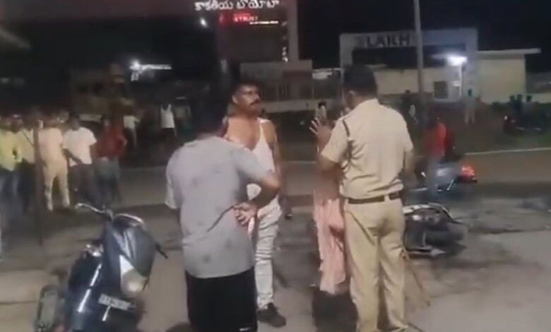 Police officer and civilians involved in a confrontation on a street at night.