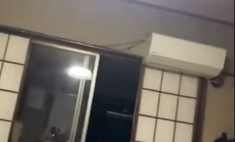 Indoor scene with air conditioner and tiled wall, no visible damage or earthquake effects.