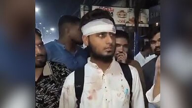 Madrassa student with a bandaged head surrounded by people in a crowded area.