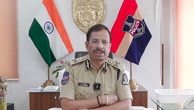 Hyderabad Police Commissioner VC Sajjanar in uniform with Indian and police flags behind him.