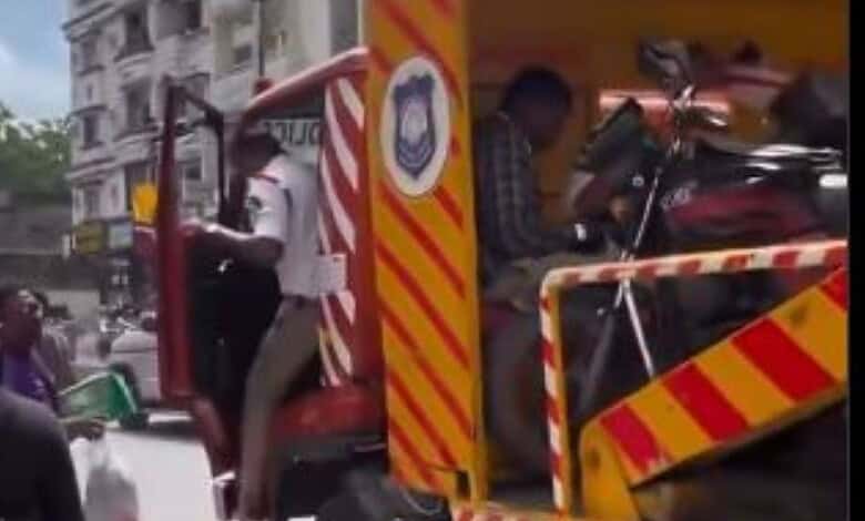 Police officials pushes a delivery agent away after seizeng vehicle in Hyderabad