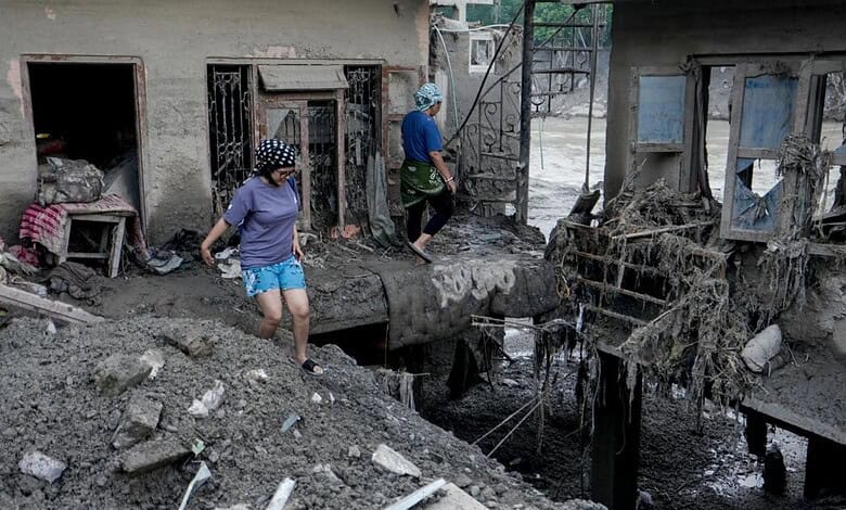 Rescue workers and residents navigate flood-damaged area in Nepal after devastating flash floods.