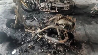 Burnt motorcycle remains after fire in Hyderabad apartment, six bikes gutted.