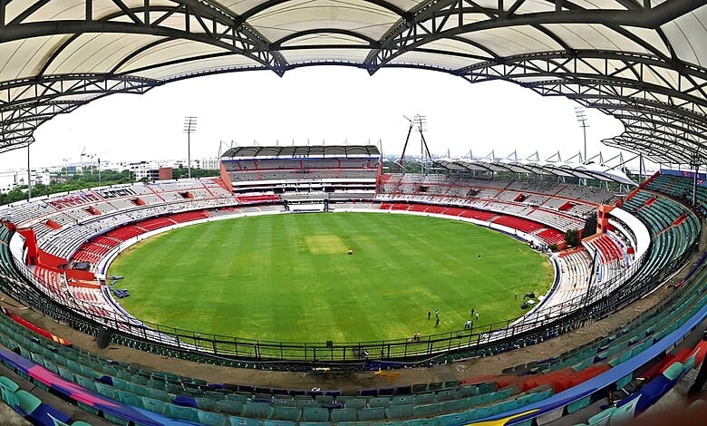 Uppal cricket stadium with empty stands and green pitch under a large roof structure.