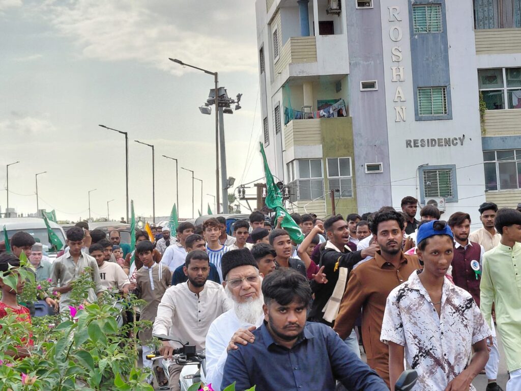 Large crowd of people participating in a religious procession in Hyderabad during Milad celebrations.