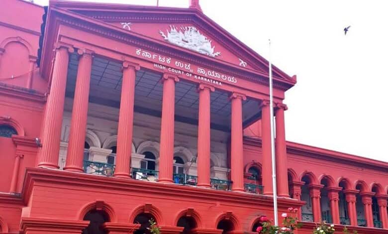 Historic red courthouse building with columns and Kannada script at the top.