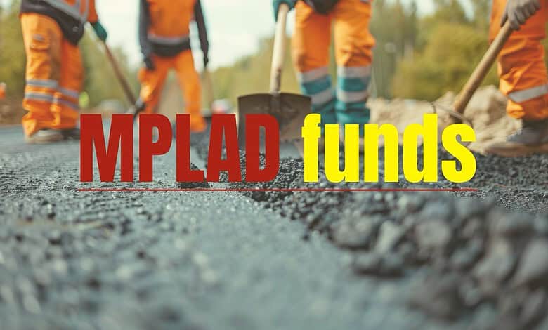 Workers laying asphalt on a road with MPLAD funds text overlay.
