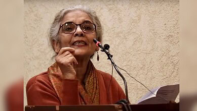JNU professor speaking passionately at a podium during a speech event.