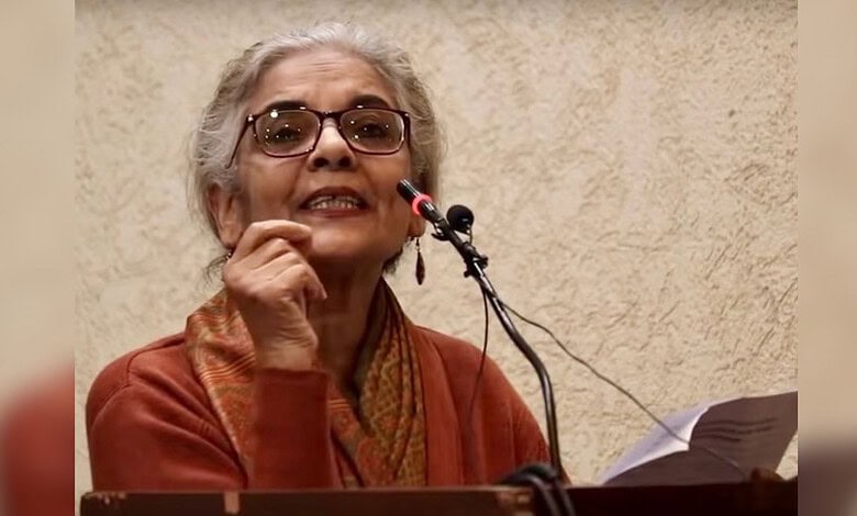 JNU professor speaking passionately at a podium during a speech event.