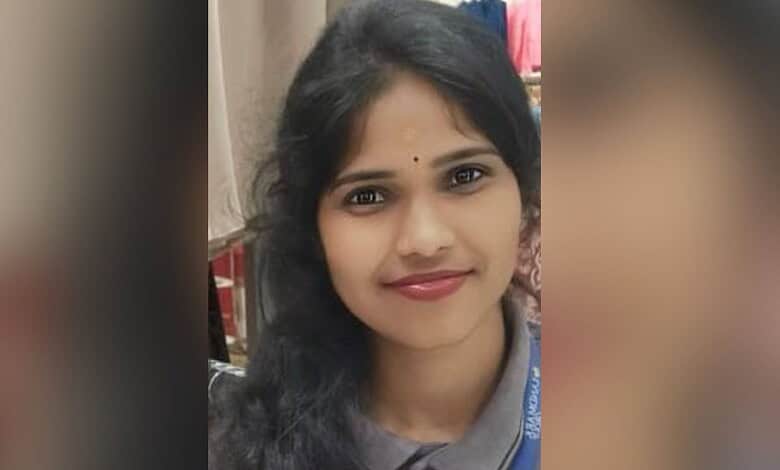Close-up of a young woman with black hair and a bindi, smiling at the camera.