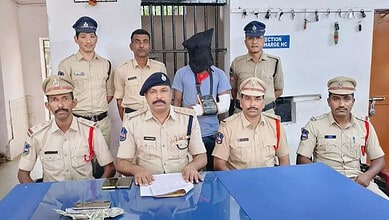 Police officers with a man in a hoodie and mask in a police station.