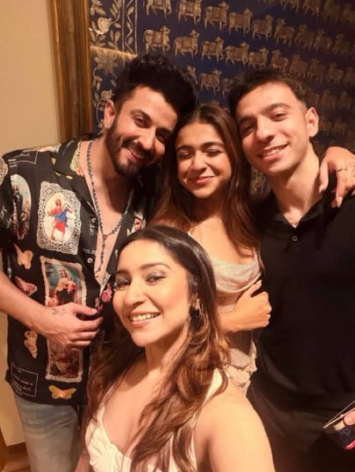 Four young adults smiling and enjoying a night out together.