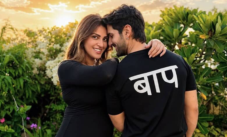 Happy couple embracing outdoors, woman smiling, man with 'Bapu' written in Hindi on his shirt.
