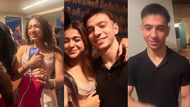 Young woman smiling and taking a selfie at an indoor event with friends.
