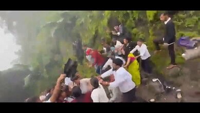 Group of people involved in a physical altercation on a hillside at Sinhagad.