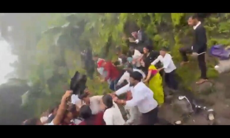 Group of people involved in a physical altercation on a hillside at Sinhagad.