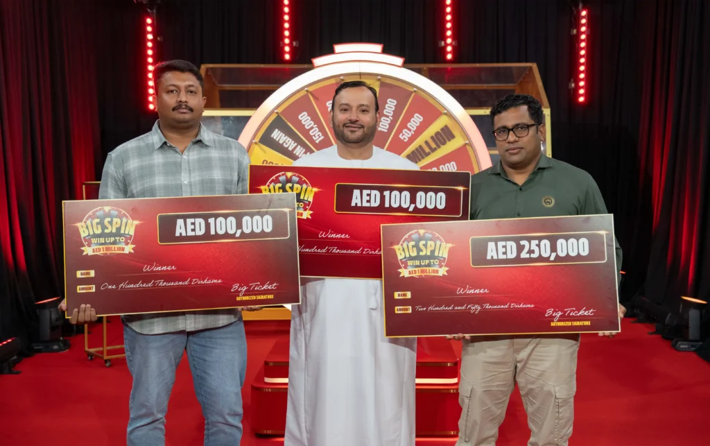 Three Big Ticket Big Spin winners hold their winning cheques.