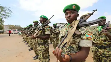 Ugandan soldiers in uniform holding rifles during a training or parade event.