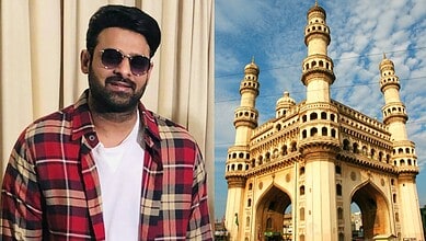 Man in sunglasses and plaid shirt standing near a replica of Charminar in Hyderabad.