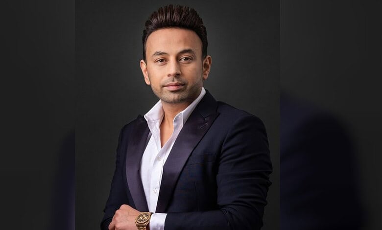 Satish Sanpal poses for a portrait in a dark suit.