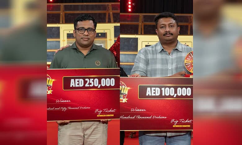 Two Indian men holding large cheque checks for Rs 77L at Abu Dhabi Big Ticket event.