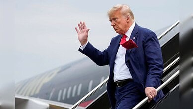 Former US President Donald Trump waves as he disembarks from an aircraft in Turkey.