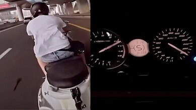 Biker riding a scooter at high speed on a city road, performing stunts.