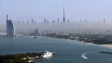Aerial view of Dubai skyline with Burj Khalifa and iconic buildings in foggy weather.