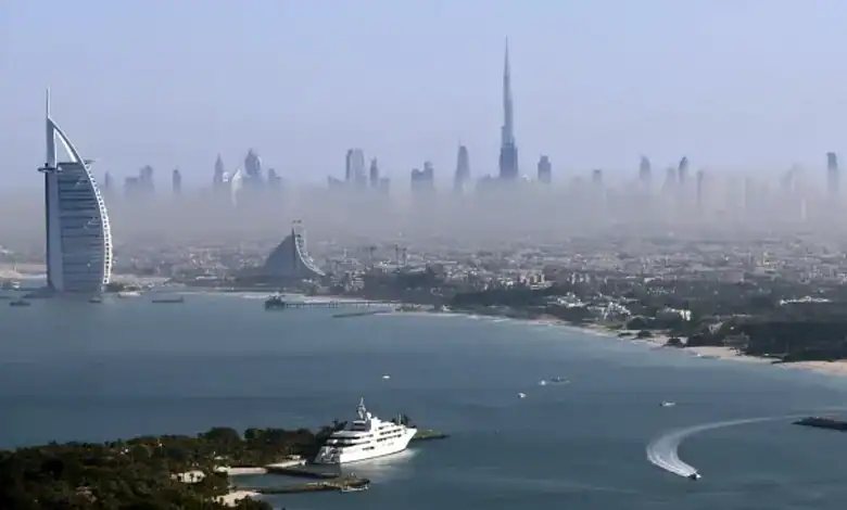 Aerial view of Dubai skyline with Burj Khalifa and iconic buildings in foggy weather.