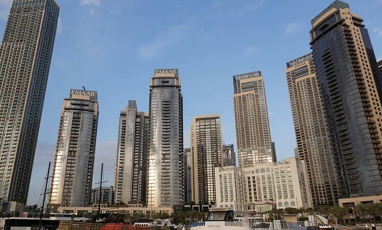 Dubai skyline featuring tall modern skyscrapers against a blue sky.