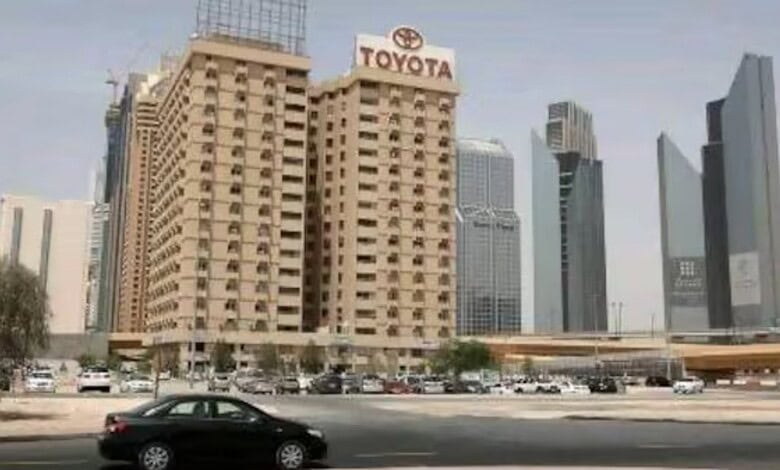 Tall Toyota building with surrounding skyscrapers in a busy cityscape.