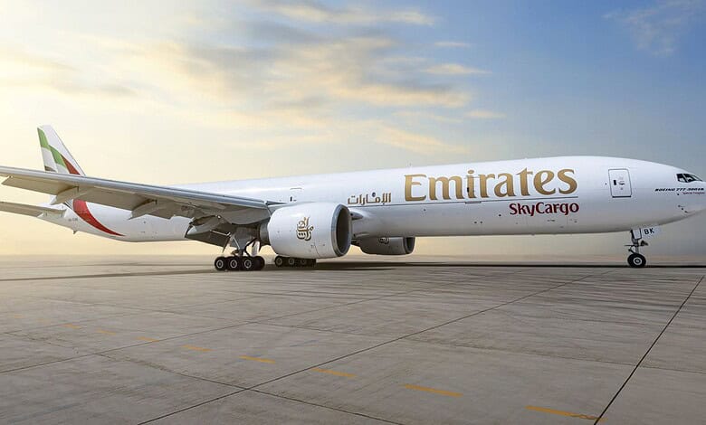 Emirates SkyCargo Boeing 777-300ER freighter parked on the tarmac at sunrise/sunset.