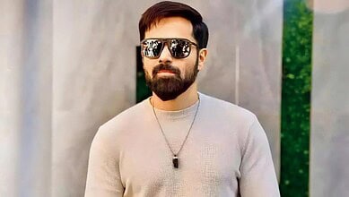 Emraan Hashmi in casual attire with sunglasses and a necklace outdoors.