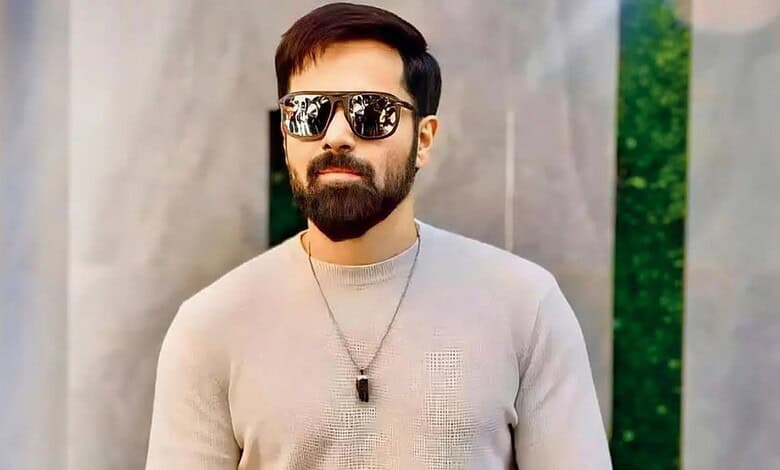Emraan Hashmi in casual attire with sunglasses and a necklace outdoors.